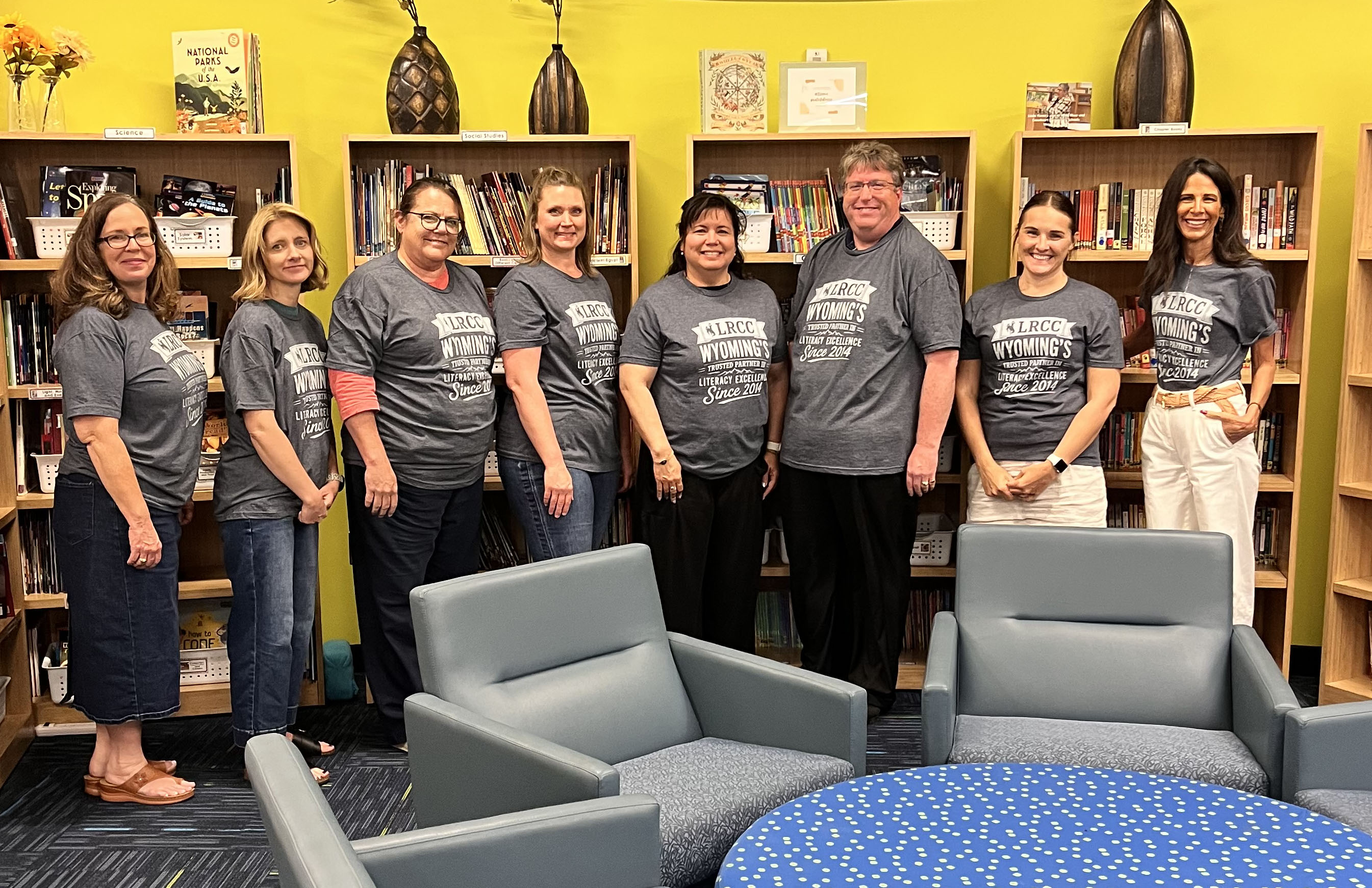 Teachers standing in a library taking a photo