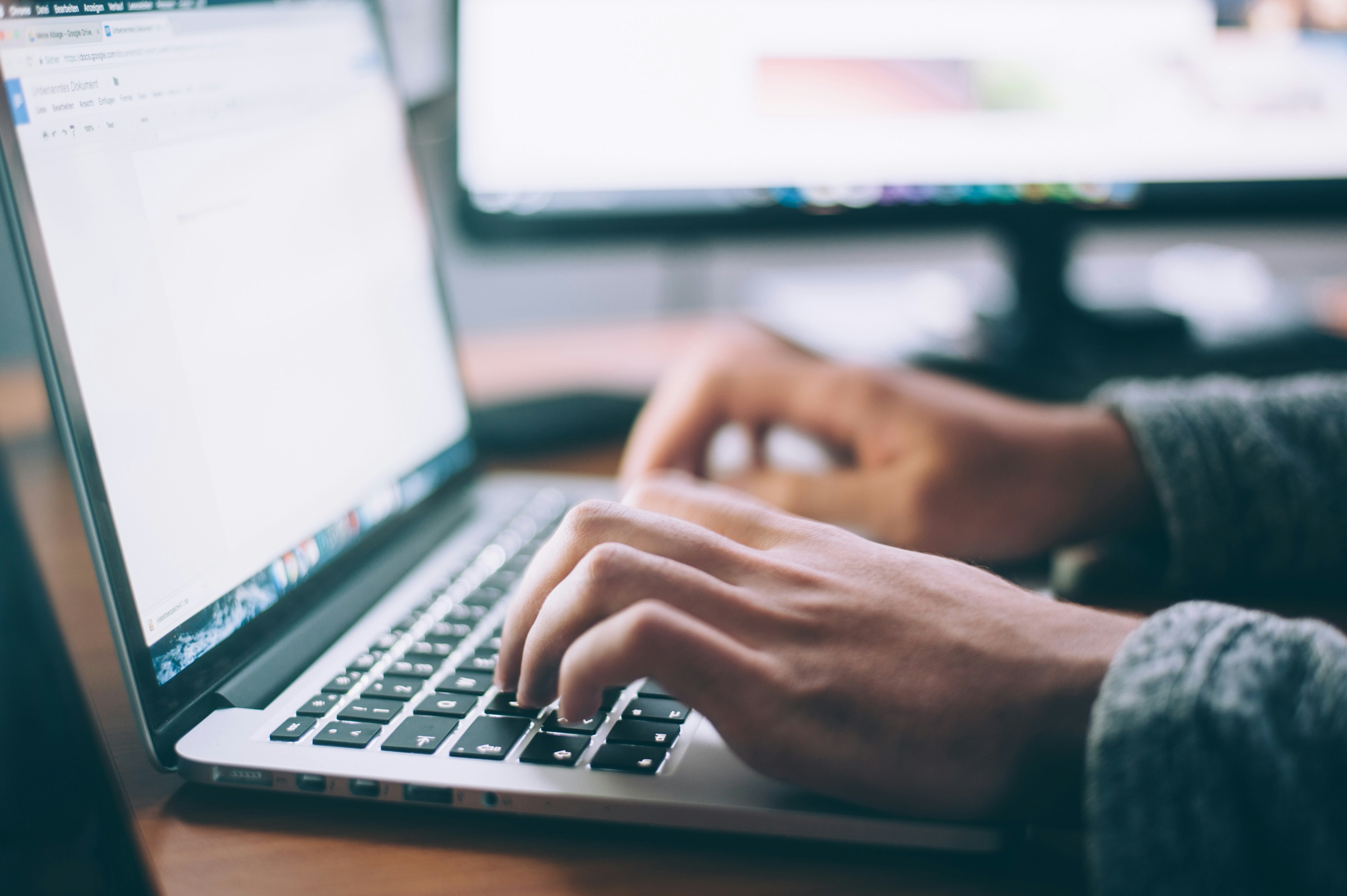 person typing on a laptop at a desk