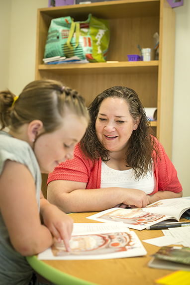 teacher working with student in classroom