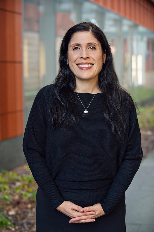 A woman standing in front of a dark background