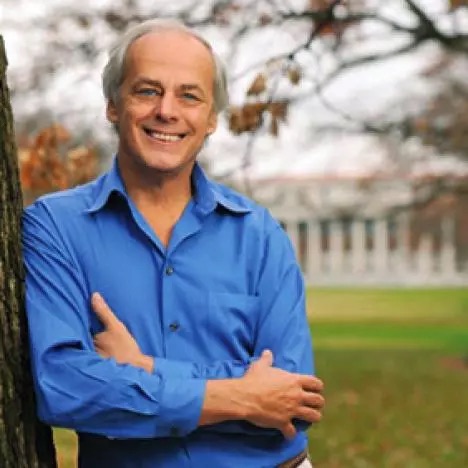 A man leaning up against a tree