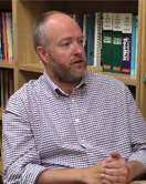Dr. Andrew Peterson leads a discussion in a library