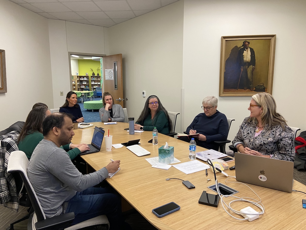faculty and staff listening to a visiting professor at a conference table