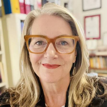 a woman in a classroom smiling at the camera