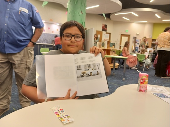 a boy holding up his book