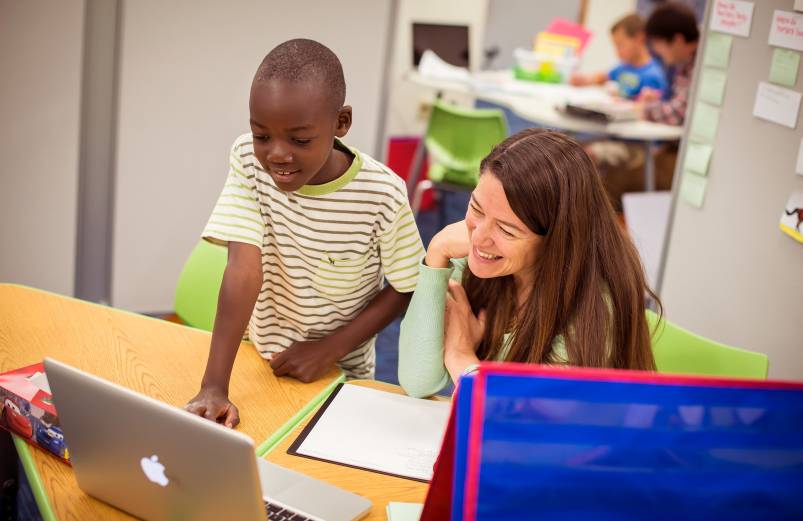 an instructor and student work at a desk