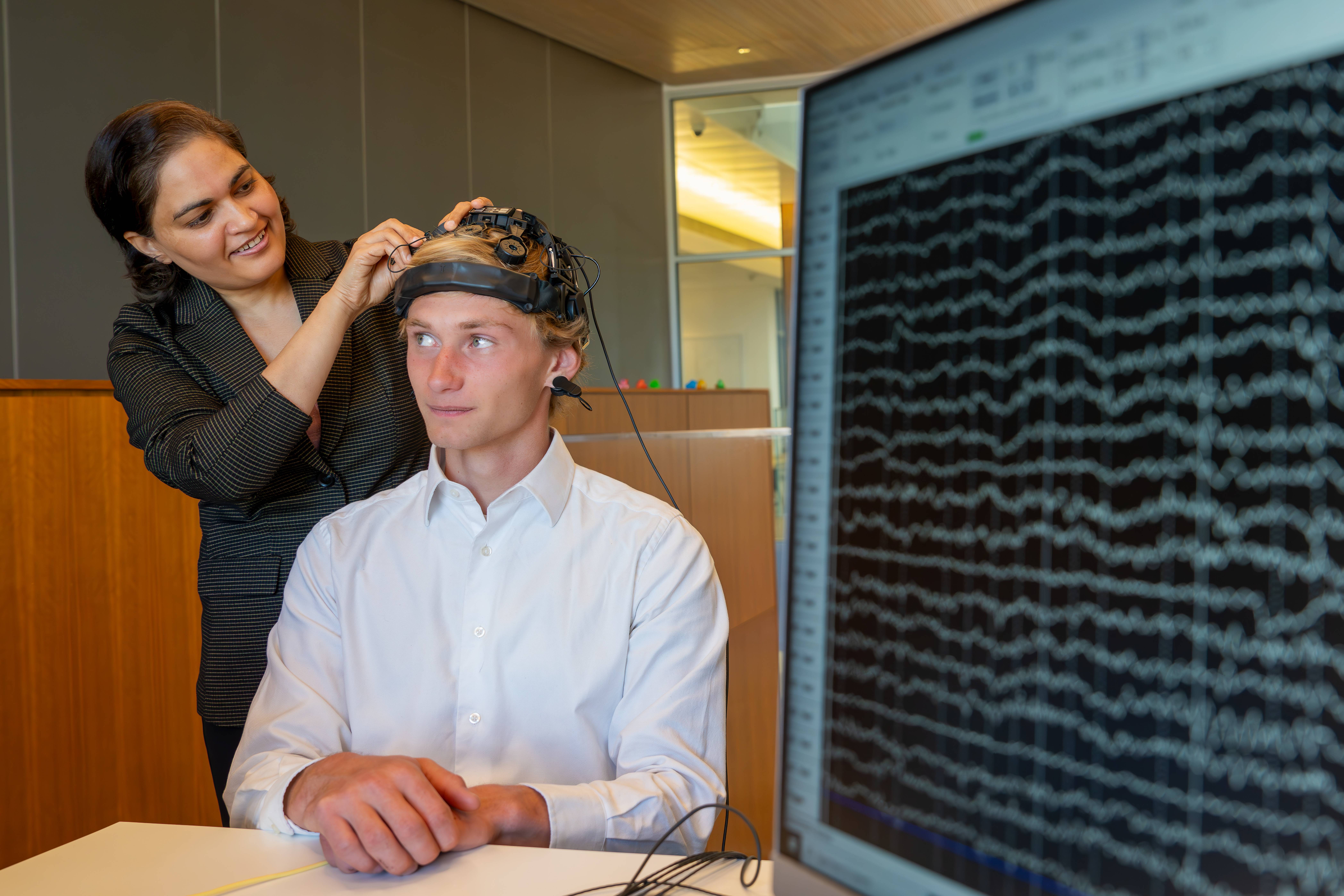 Dr. Shukla attaches brain monitoring device to student