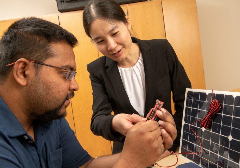 Two people work on an electrical engineering project together
