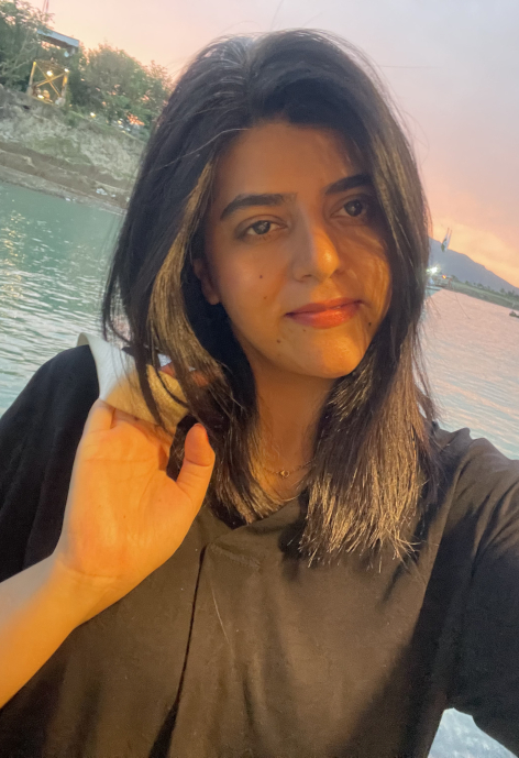Selfie of Aqsa Ishaq standing in front of water.