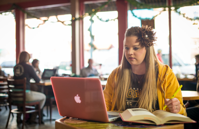 A student works on homework at a coffee shop.