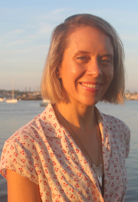 Smiling woman wearing a white blouse with cherries