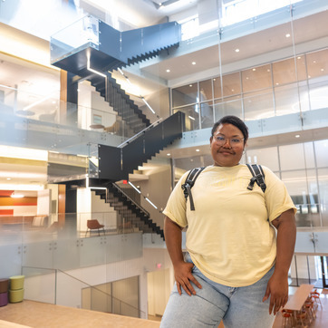 student smiling at the camera wearing a backpack