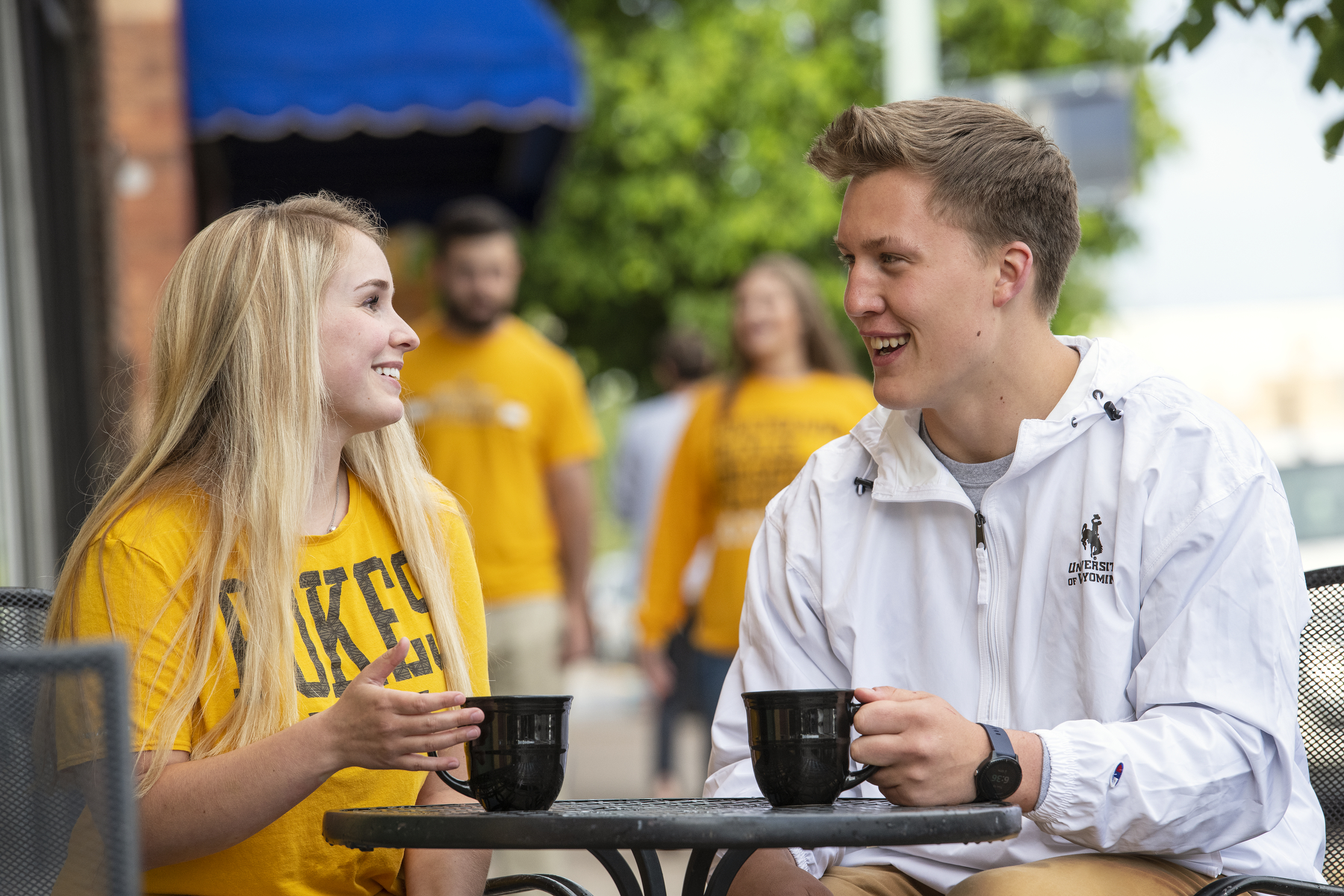 two students talk over a coffee downtown