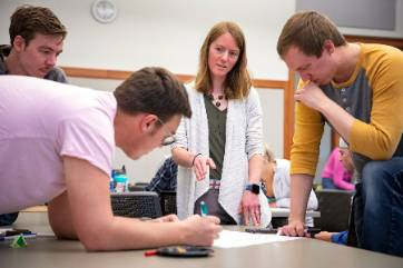a professor helps students with a project