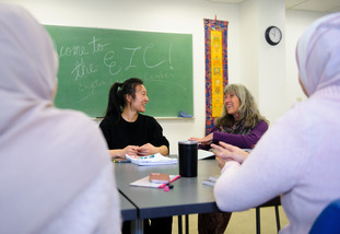 UW students and faculty smile during a group discussion at the English Language Center.