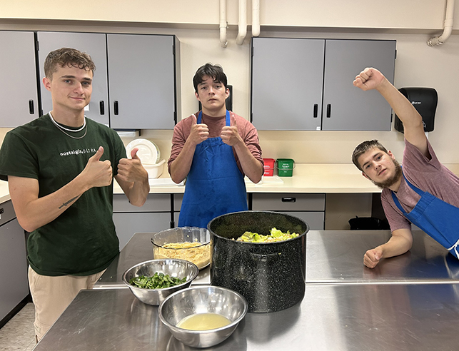 three family and consumer sciences human nutrition and food science students celebrating their final exam meal in our teaching kitchen scientific study of food