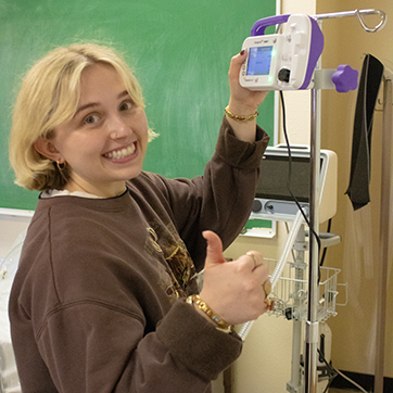 family and consumer sciences student in the graduate program in nutrition and dietetics having fun playing with an IV drip machine