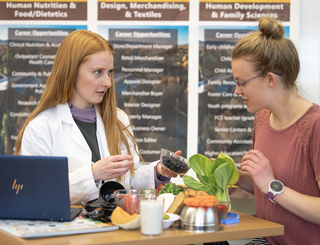 two graduate students in the human nutrition and food masters program performing sensory analysis on some food