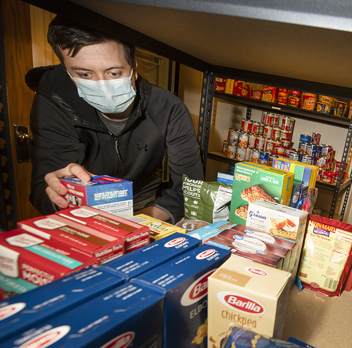 a human nutrition student sorting through some food on shelvess