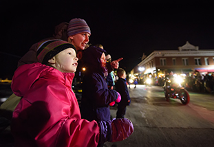 a mother and child at night pointing at something out of frame