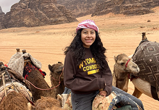 a family and consumer sciences student riding a camel on a study abroad in jordan