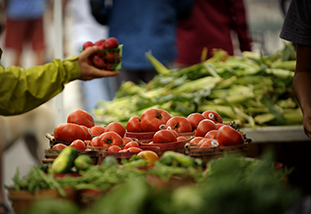 a family and consumer sciences student taking a basket of food froom a street vendor