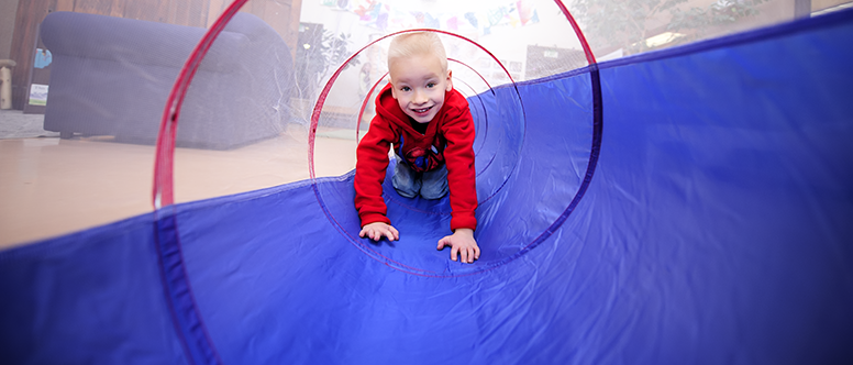 a child crawling through a tunnel that represents the human development and family science major in family and consumer sciences