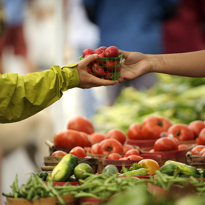 a customer taking a small basket of radishes