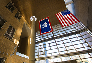 the flags of wyoming and the united states hanging in a building that houses the family and consumer sciences department
