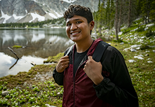 an international student in the family and consumer sciences department standing against the backdrop of wyoming's wonderful snowy range mountains