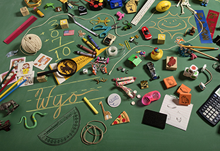 toys and trinkets on a flat chalkboard with WYO written on it