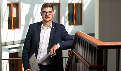 a business student poses in the College of Business lobby.