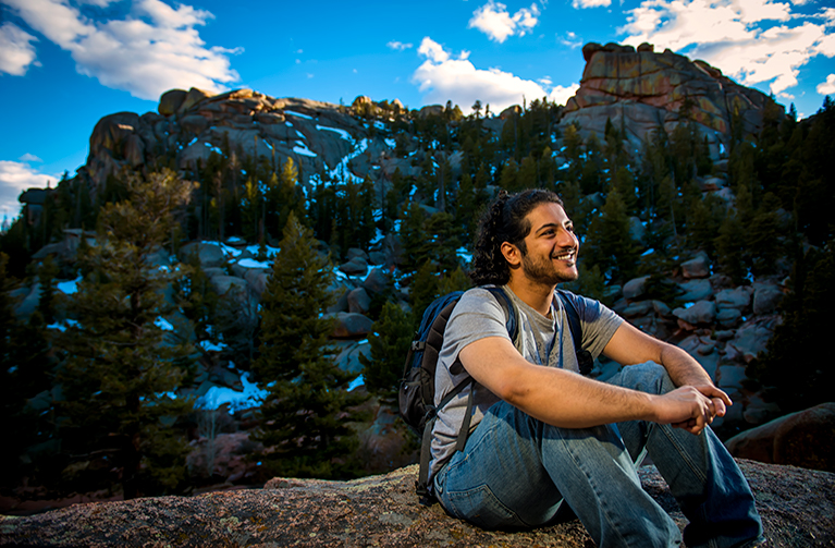 student sits on a rock at Vedauwoo