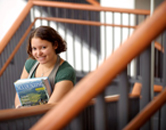 A University of Wyomimg student holds business books in the College of Business Building