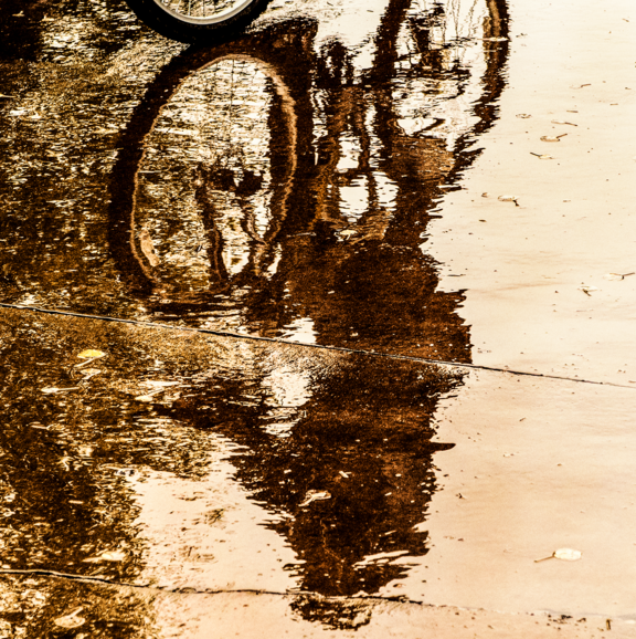 bike in reflection of a pool water on the ground