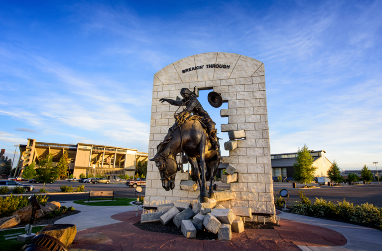 statue of horse and rider breaking through a wall