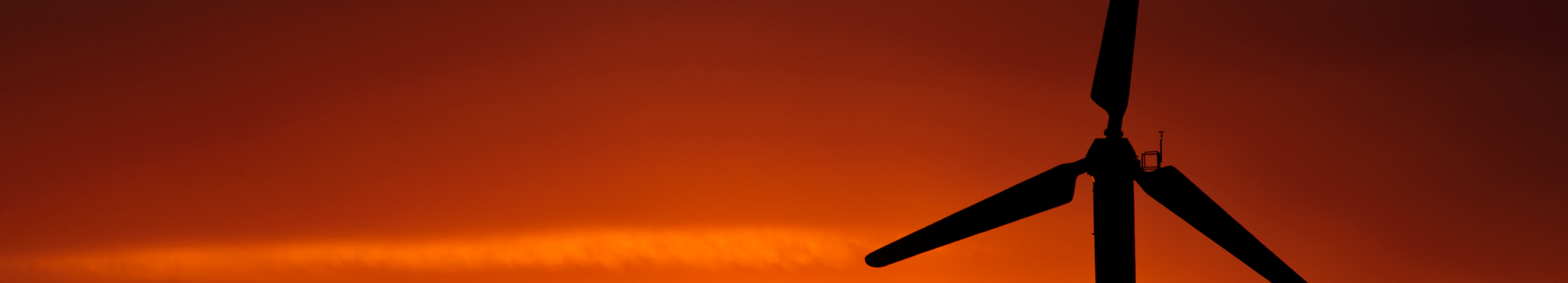 sunset behind wind turbine