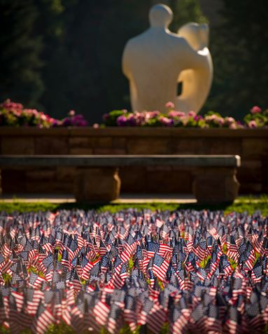 American flags in Prexy's Pasture near family statue