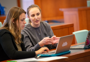 students in a class room looking at a laptop