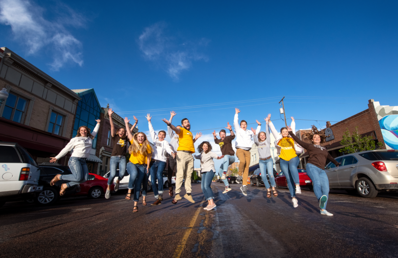 students in downtown Laramie jumping in the air
