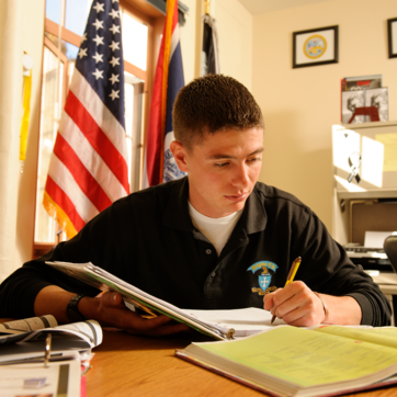 student studying with American flag in background
