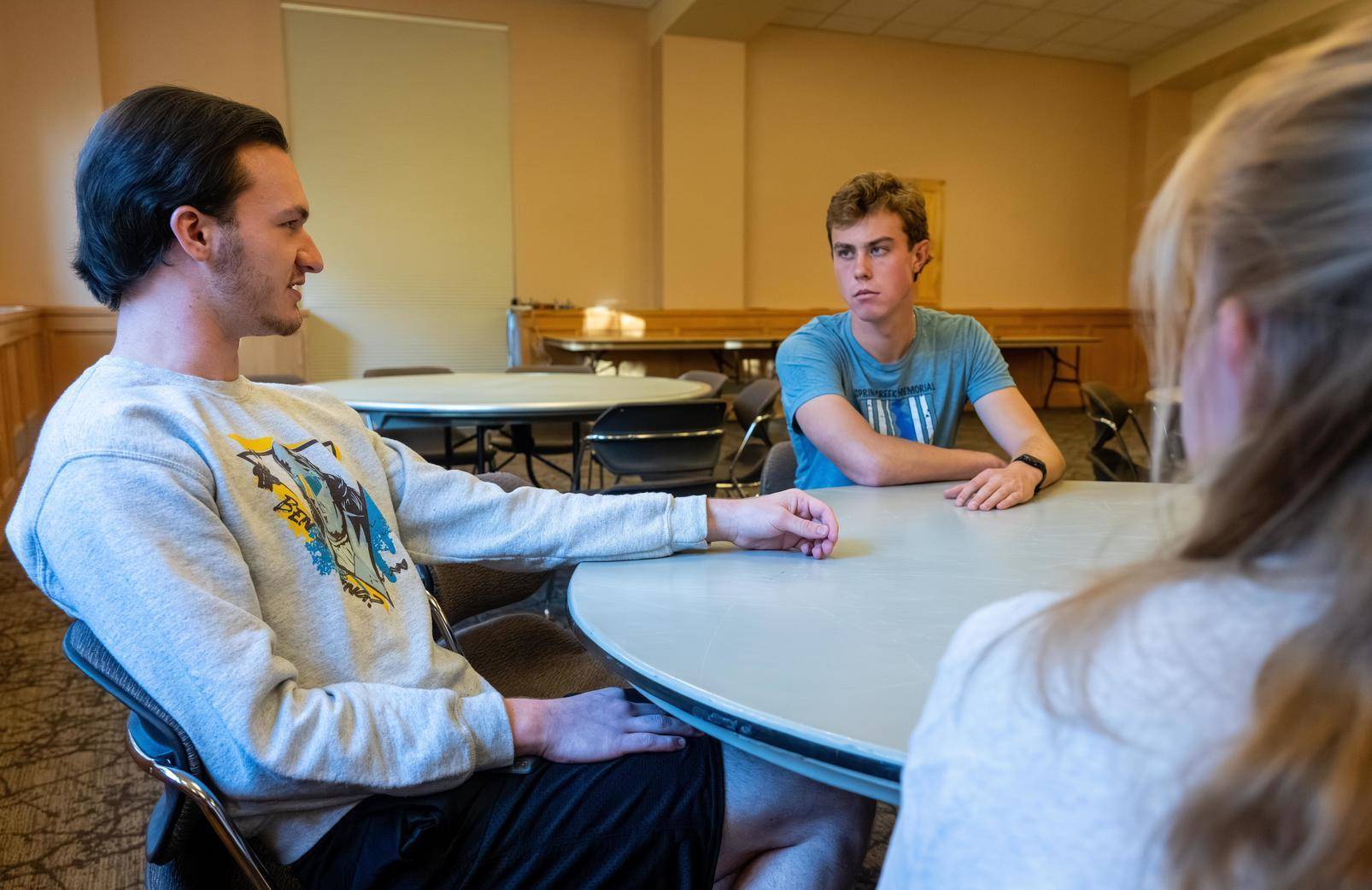 Three people having discussion at table
