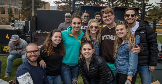 Members for the FSL Community huddle in front of a BBQ to pose for a picture