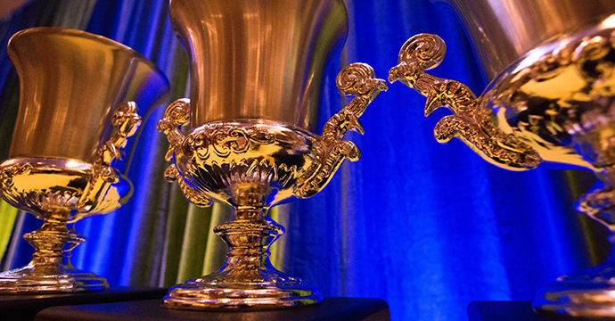 Gold awards on a table with a blue backdrop