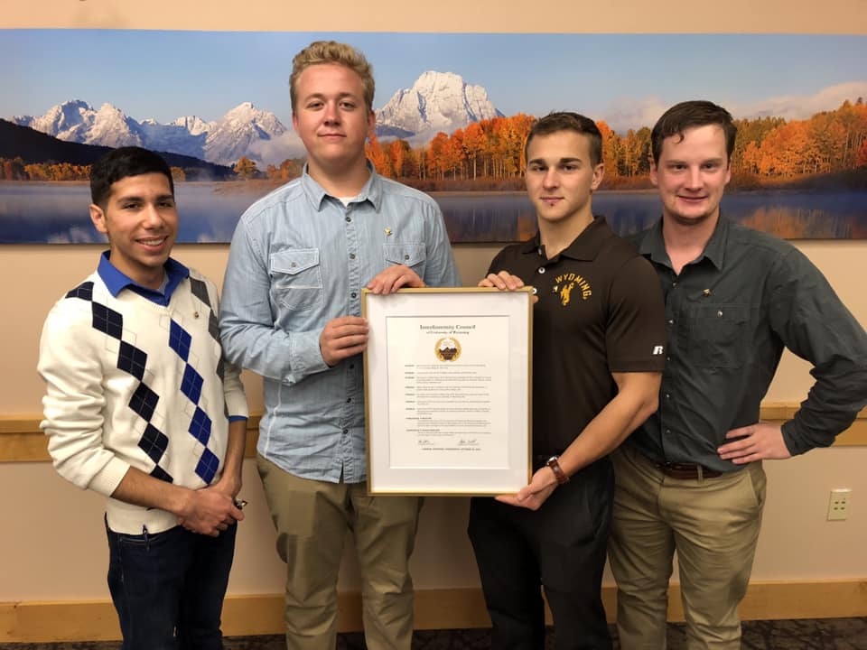 Men of the fraternity receiving documentation of their charter.
