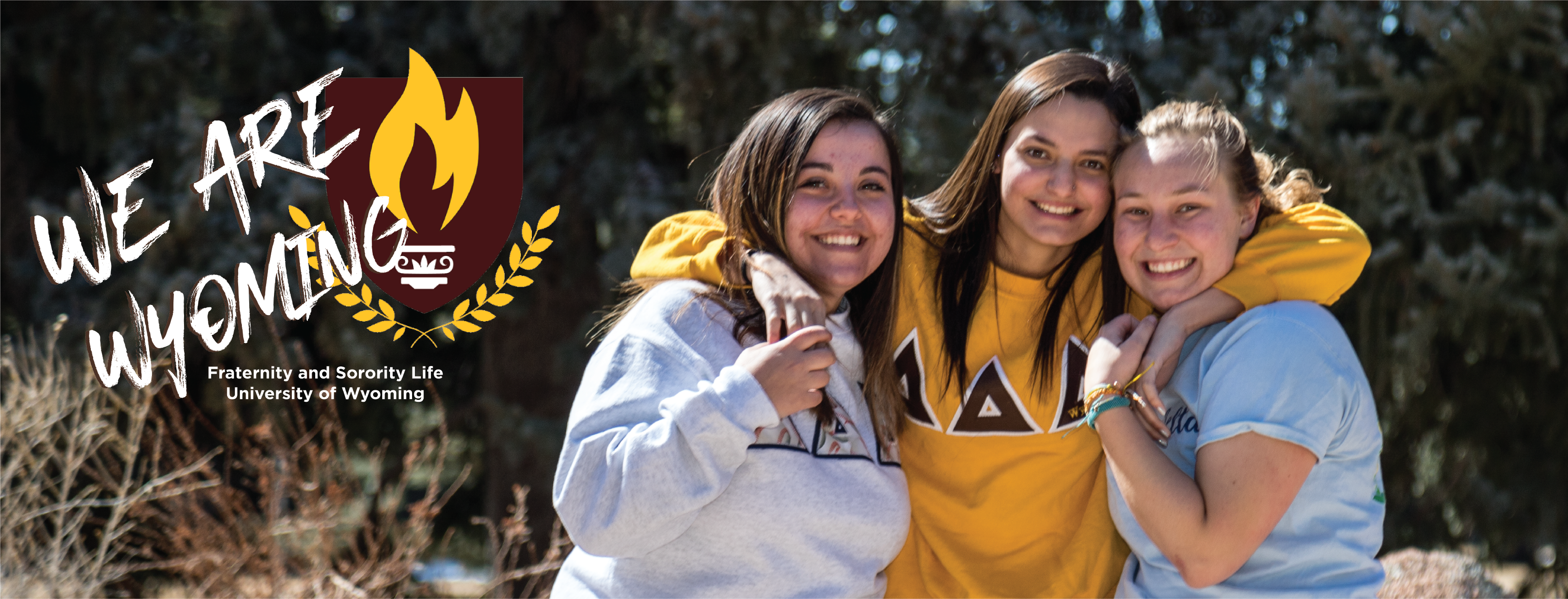 Sisters of the Delta Delta Delta Sorority pose for a picture together. All the girls are looking at the camera smiling.