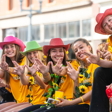 UW sorority members sit on a float and support the University of Wyoming during a homecoming parade