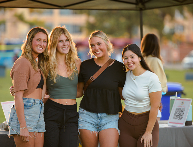 A group of students stand near their sorority tent at Cowboy Carnival