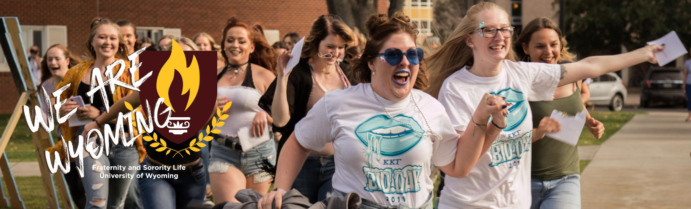 Women of Chi Omega running on bid day with FSL We Are Wyoming Logo