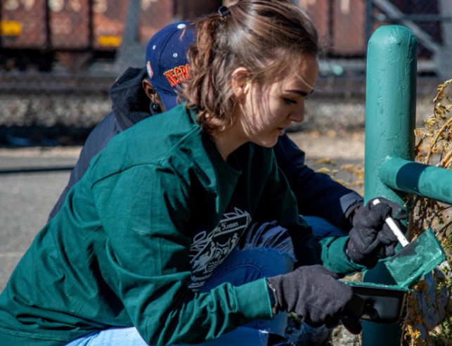 Student painting a pole